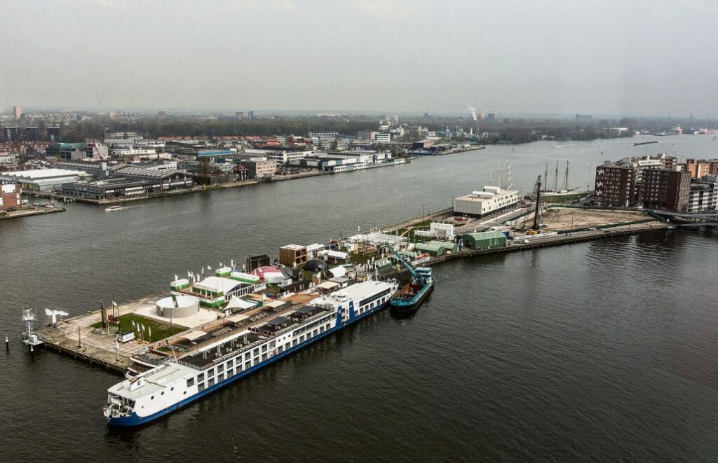 A canal view of the city of Amsterdam, The Netherlands with boats and docks.