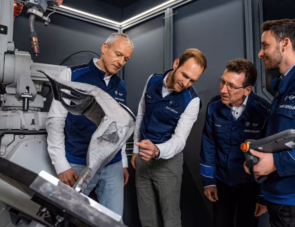 I dipendenti della BMW Automotive stanno controllando il sistema MX3D Metal AM e il robot Arc.