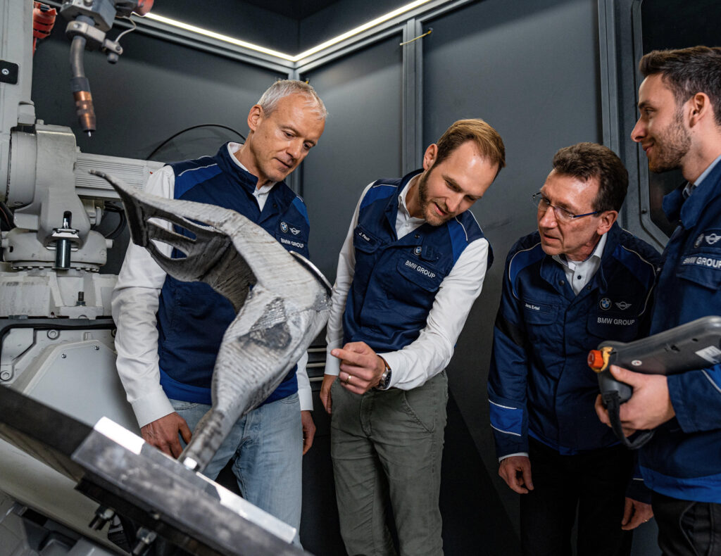 BMW Automotive employees are checking the MX3D Metal AM System and the Arc robot.